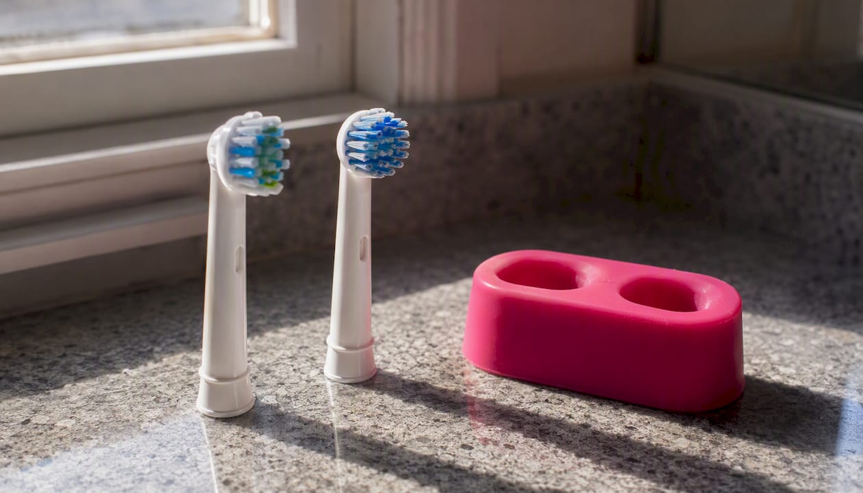 Two electric toothbrush heads drying upright