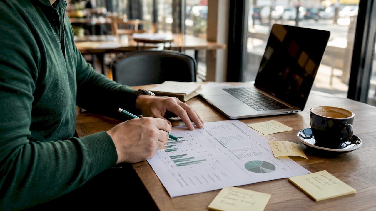Hands calculating financial data on desk with documents