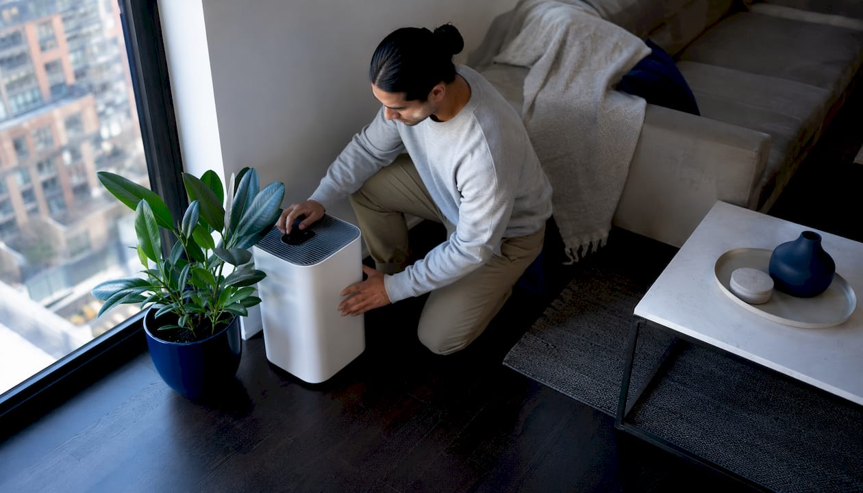 Man using HEPA air purifier in living room