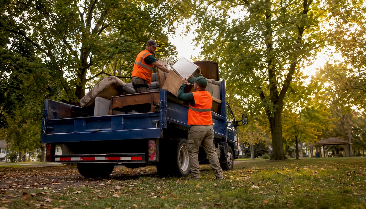 Junk removal truck loading items in neighborhood