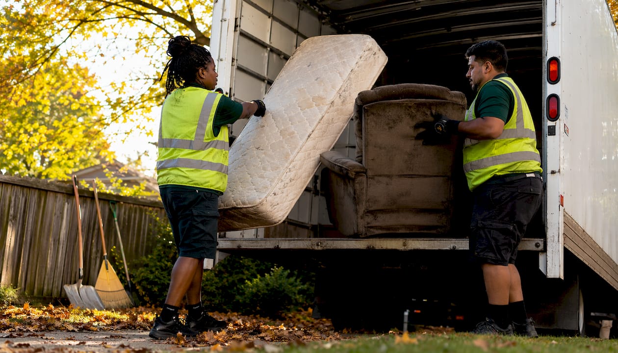 Junk removal crew loading furniture into truck
