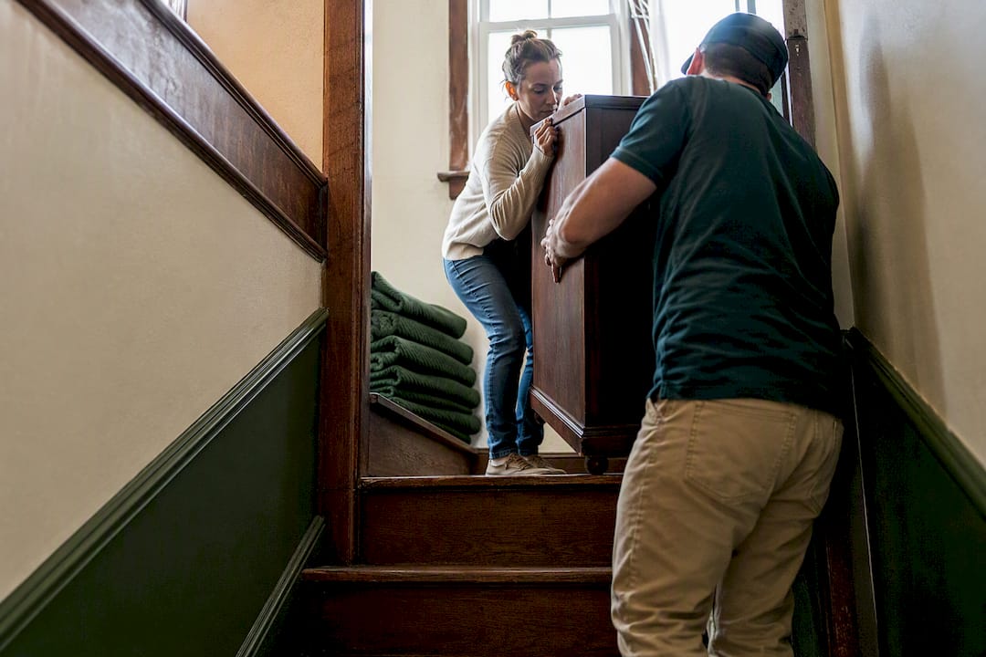 Dresser navigating a narrow basement stairwell