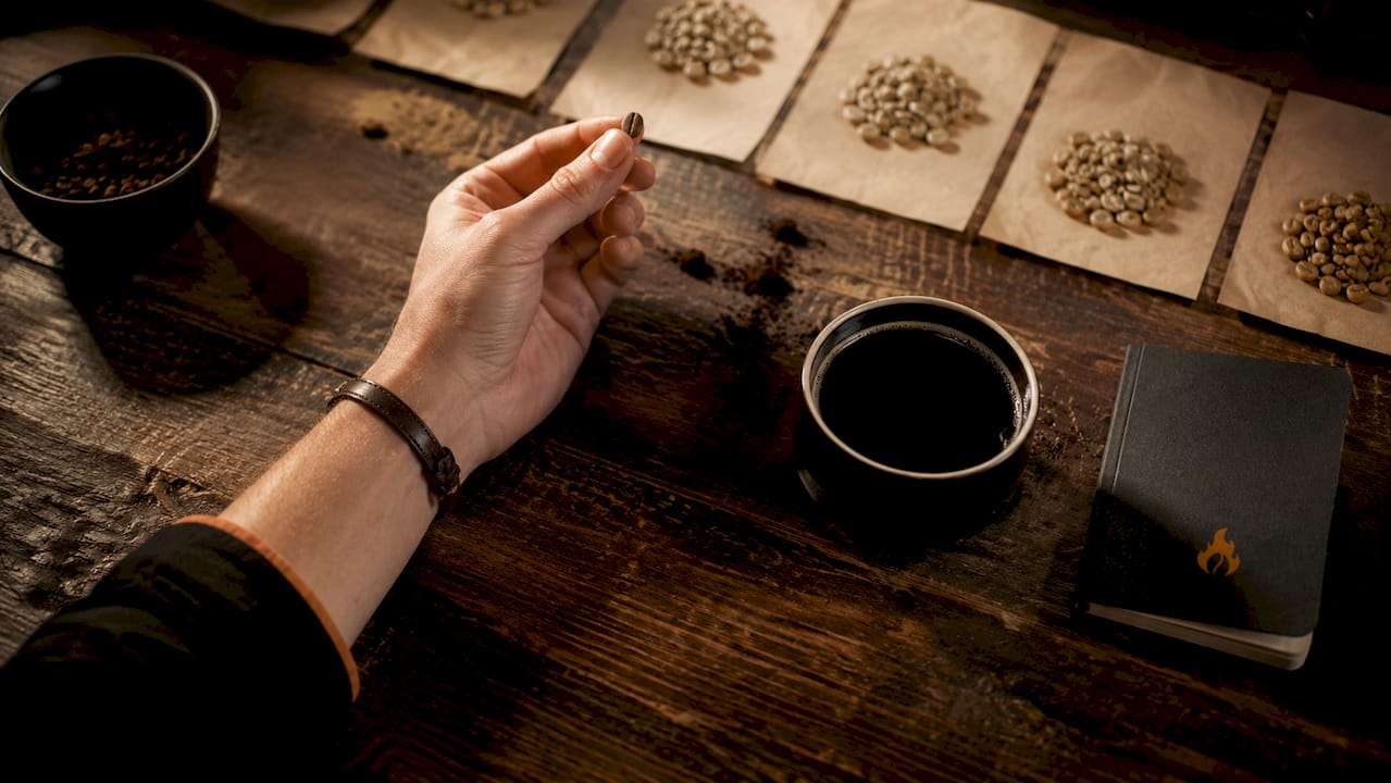 Hands inspecting coffee beans near spectrophotometer