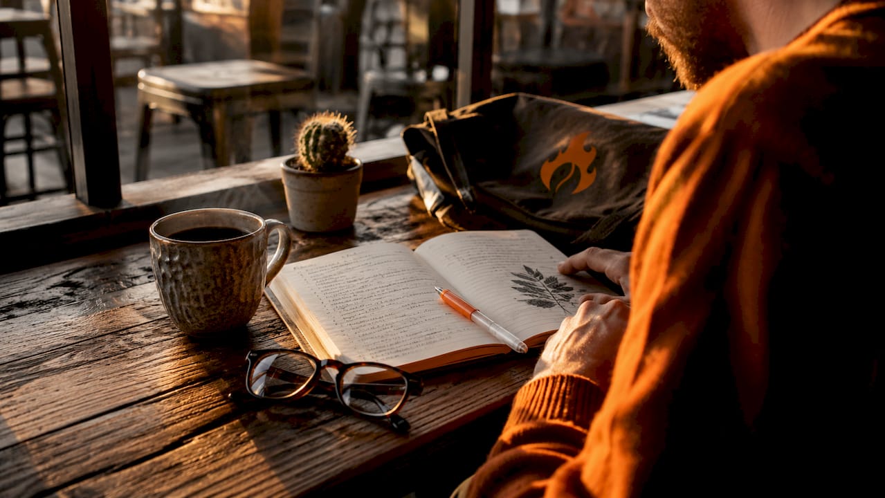 Overhead view of workspace with coffee notes and cup