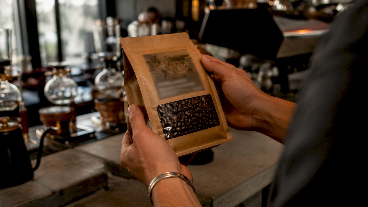 Hands holding coffee bag with origin map label