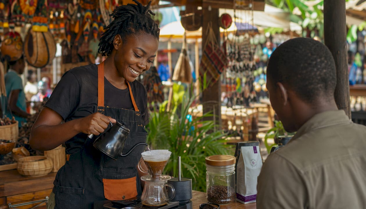 Young Ugandan barista serving coffee at local shop