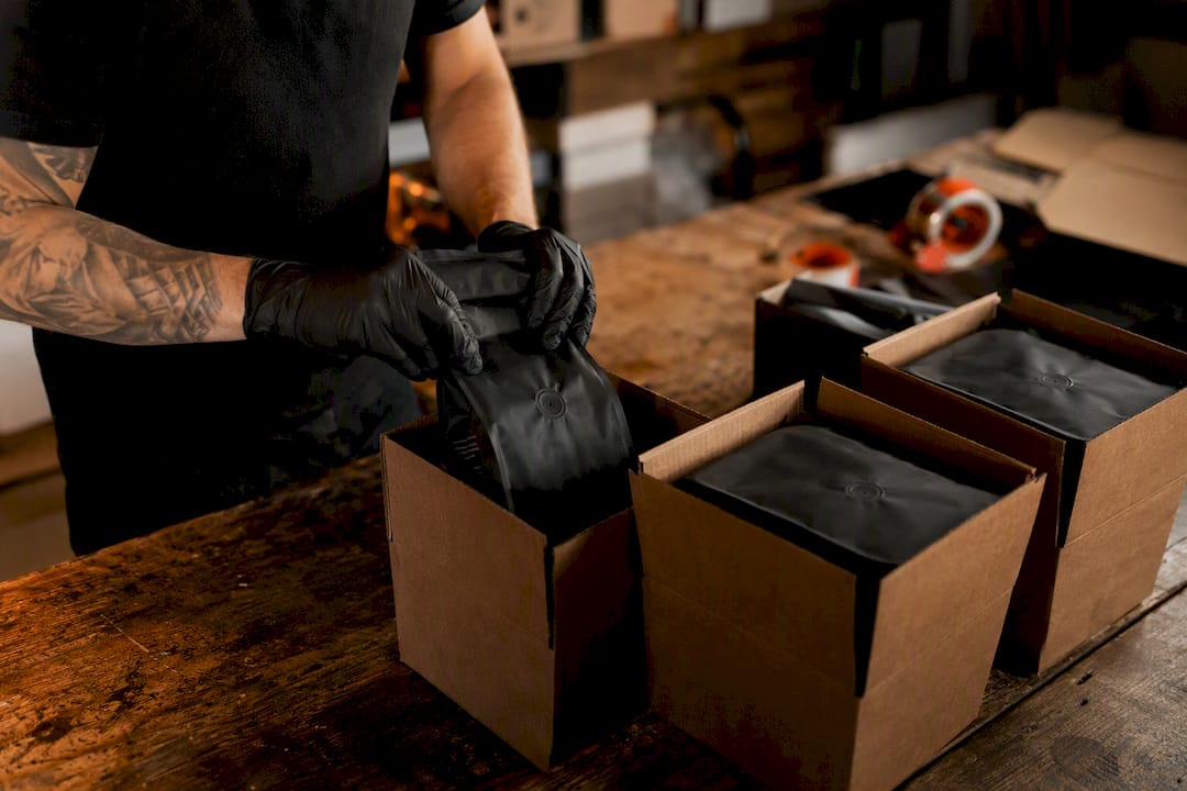 Hands packing coffee orders into boxes