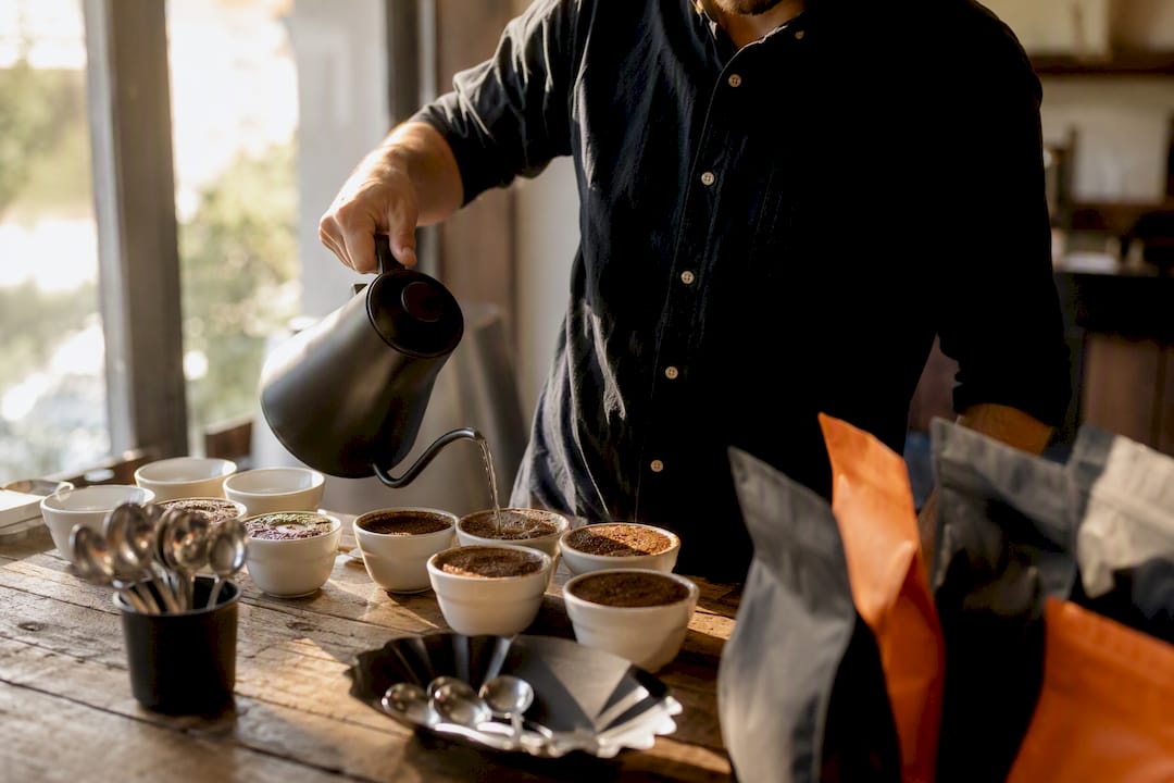 Hands scooping coffee for cupping training
