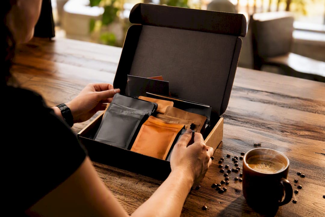 Hands unpacking curated coffee subscription box