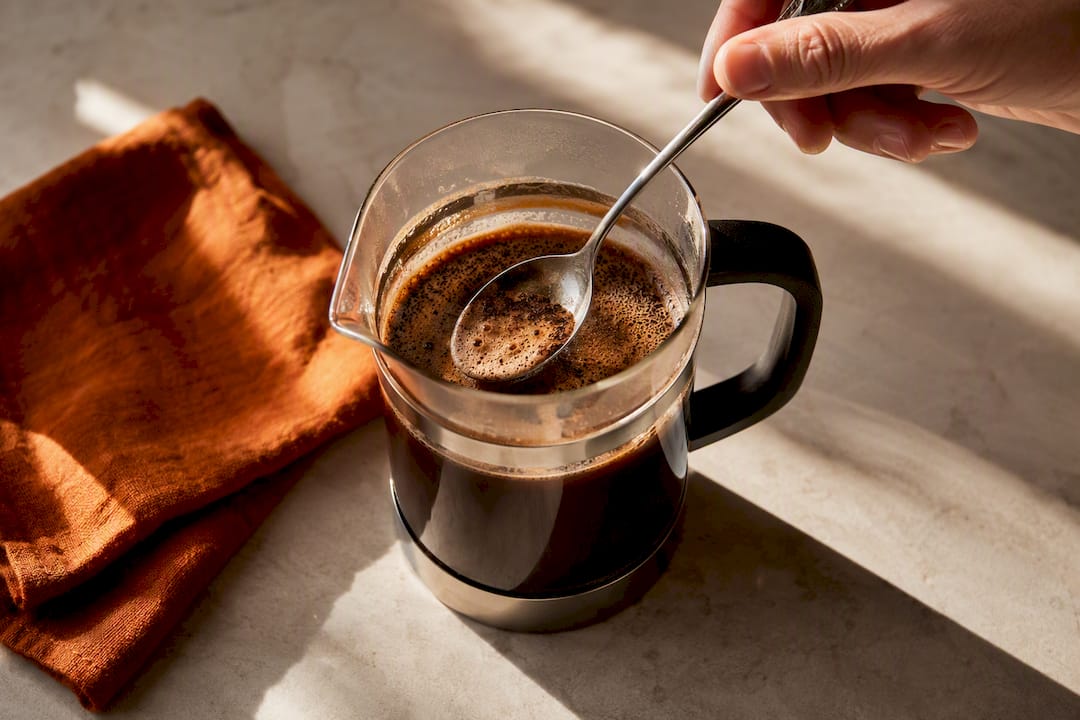 Skimming foam from freshly plunged coffee