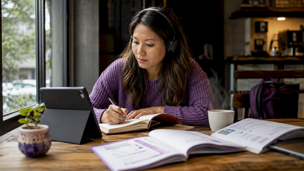 Woman practicing listening with headphones and notes