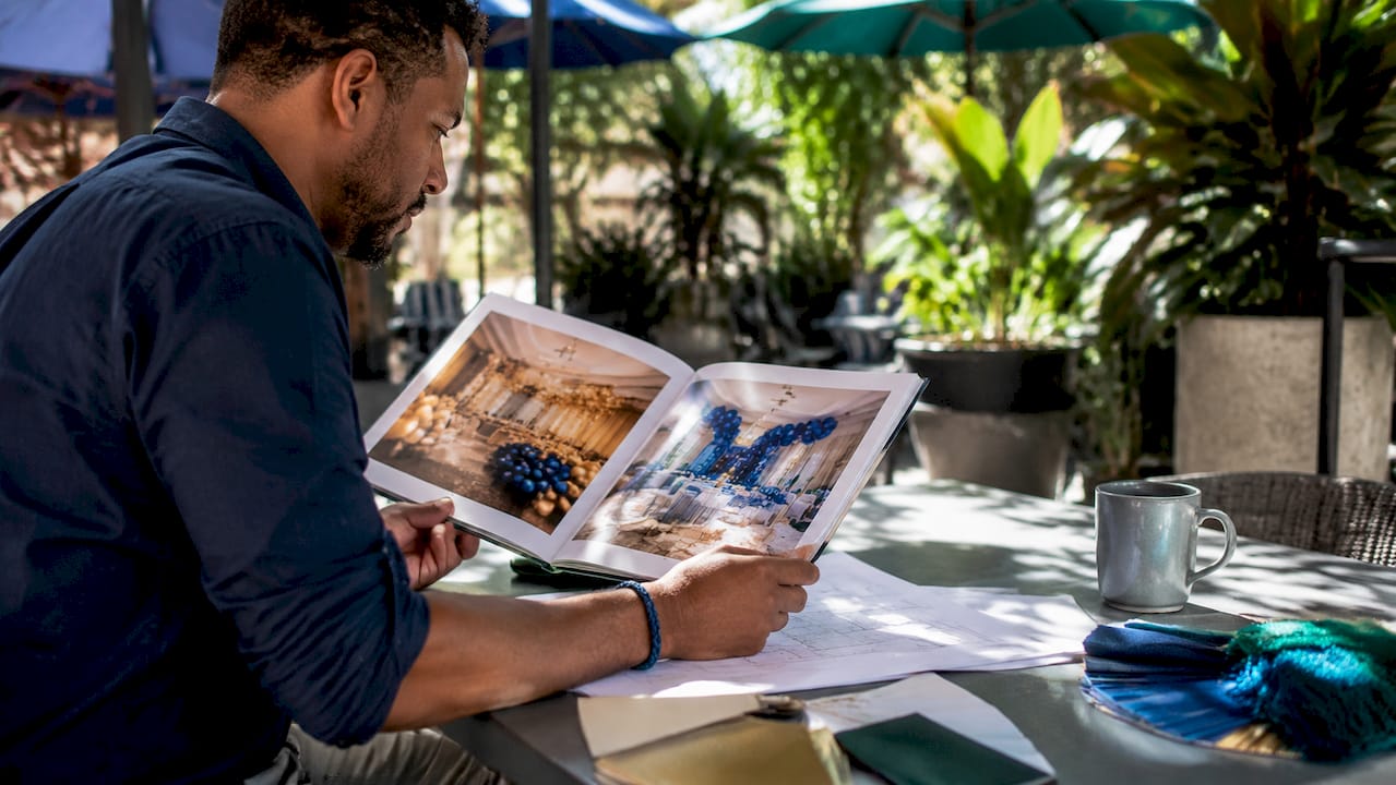 Event Decor Vendor Guide Explained for Planners Planner reviewing event decor portfolio book
