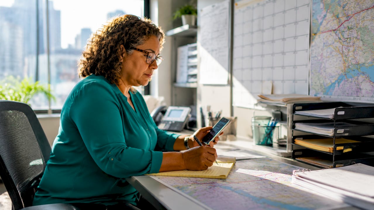 Logistics coordinator managing courier routes in office