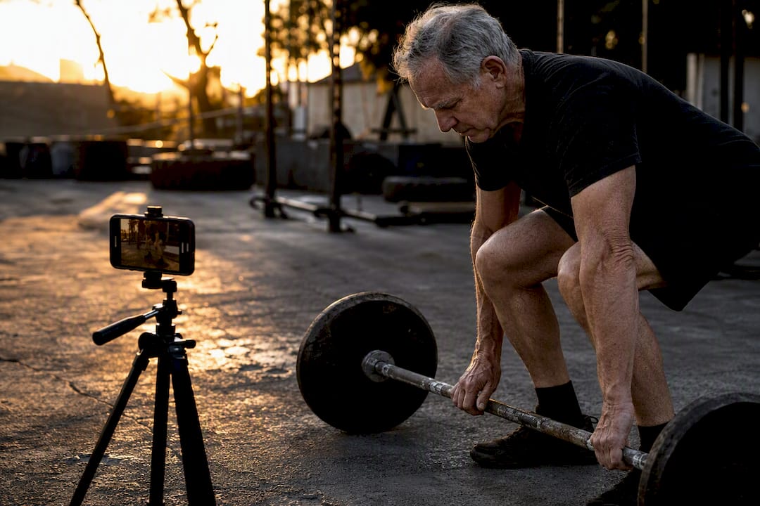 Older lifter filming deadlift setup from side