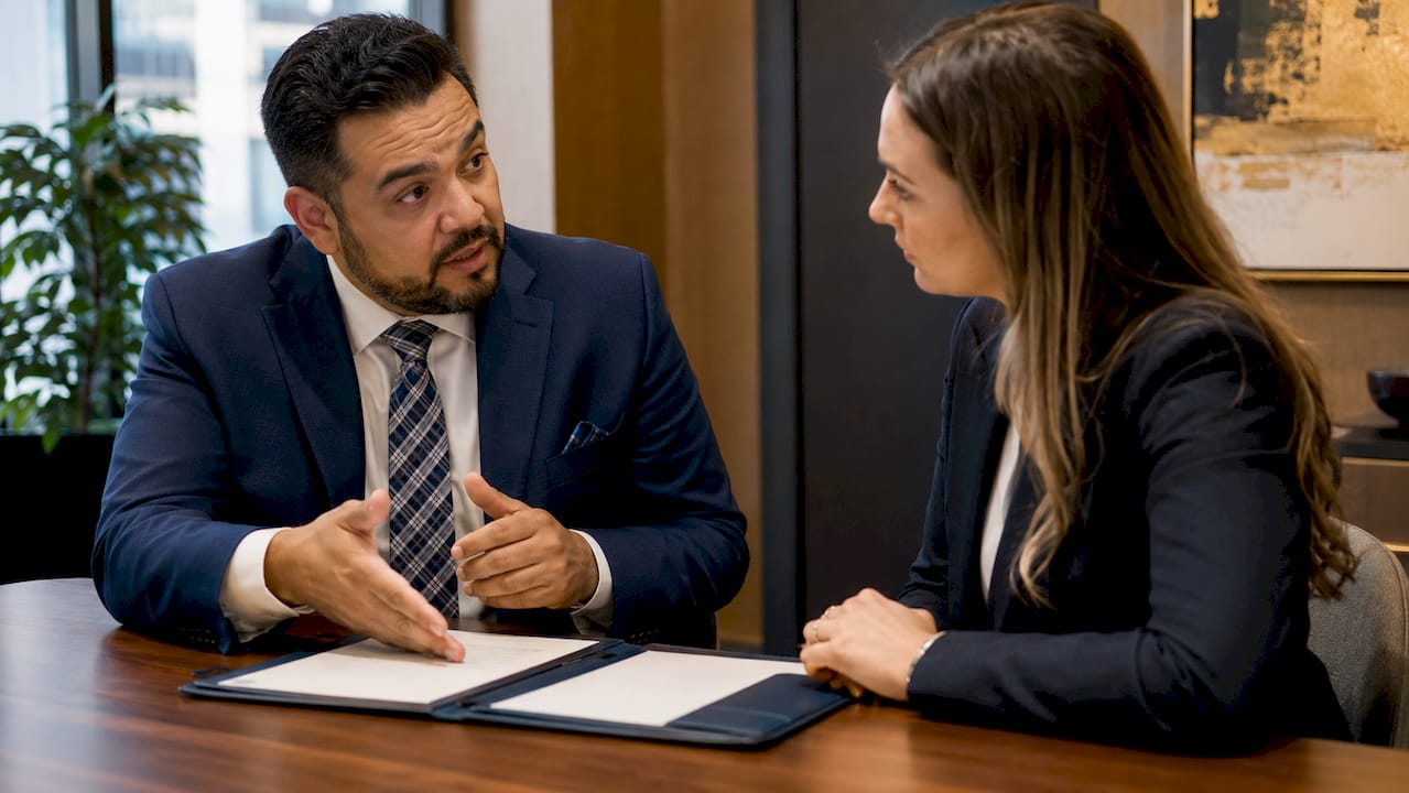 Bank advisor discussing product with client in corporate office
