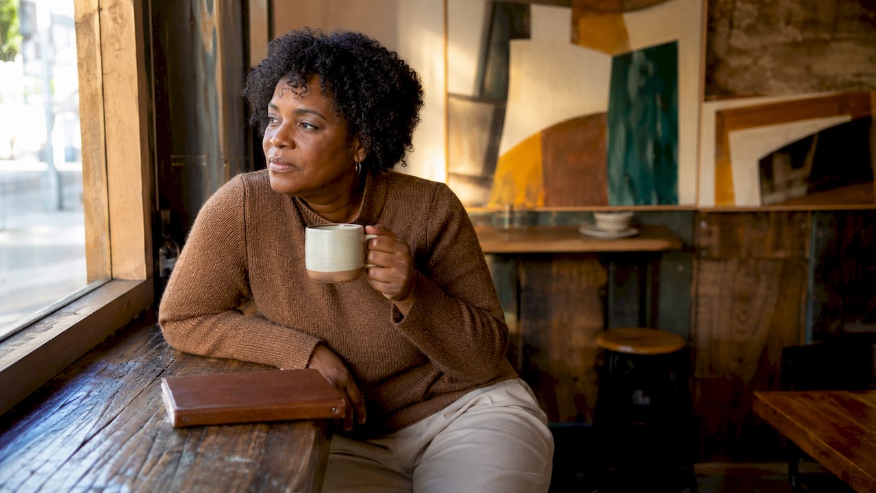 Woman reflecting on modern knight values at kitchen table