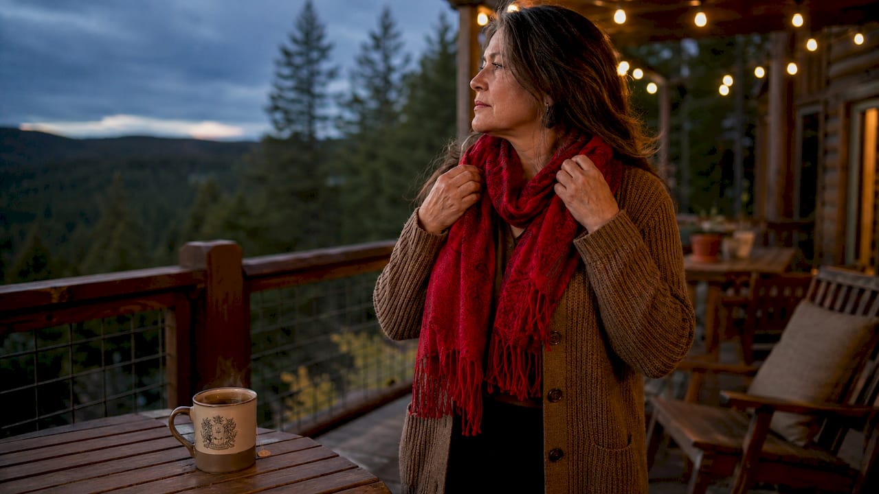 Woman adjusting red scarf indoors symbolizing tradition