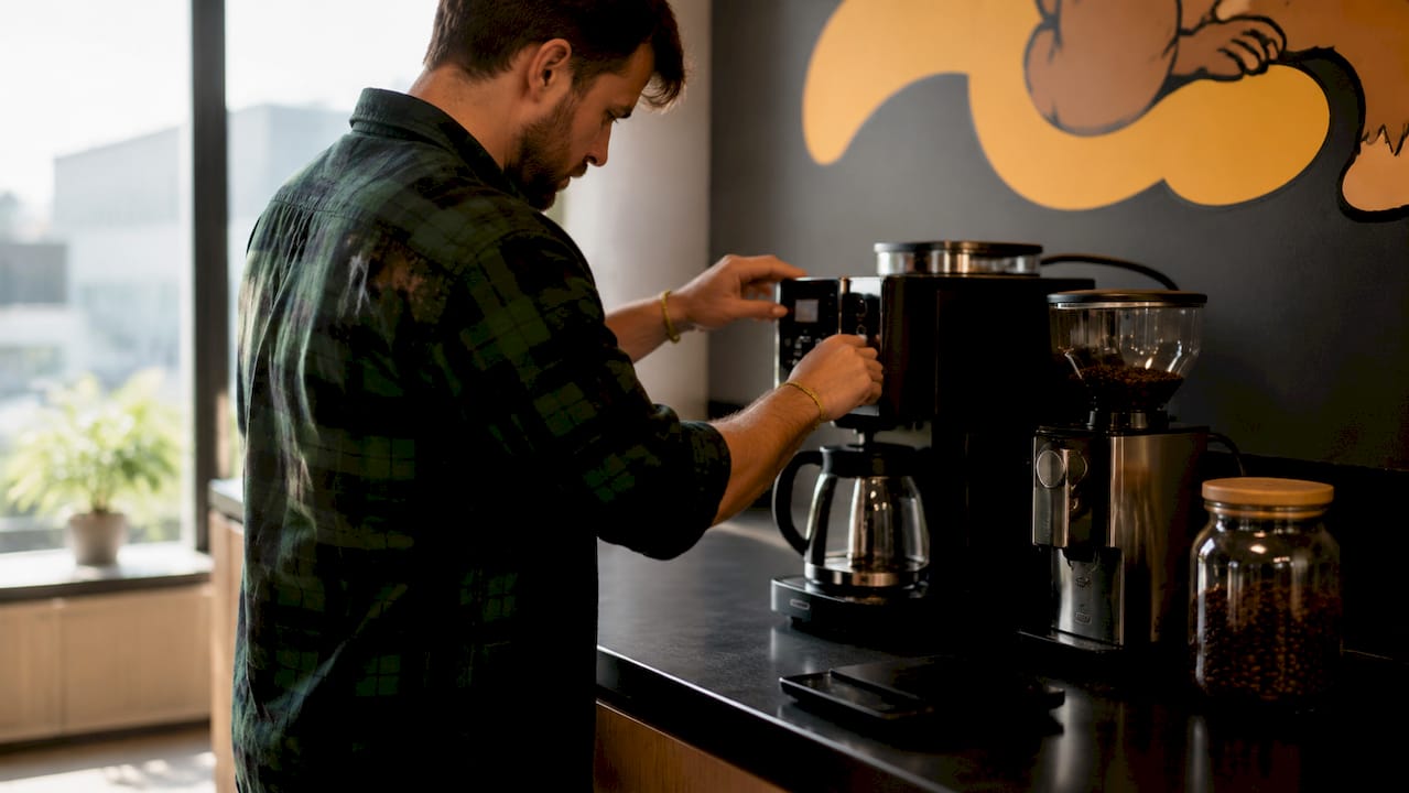 Hands adjusting office coffee machine settings