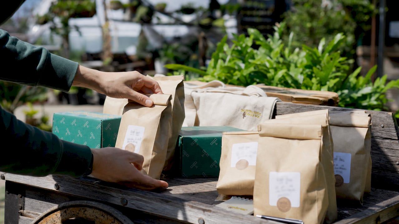 Hands arranging freshly roasted coffee bags on shelf