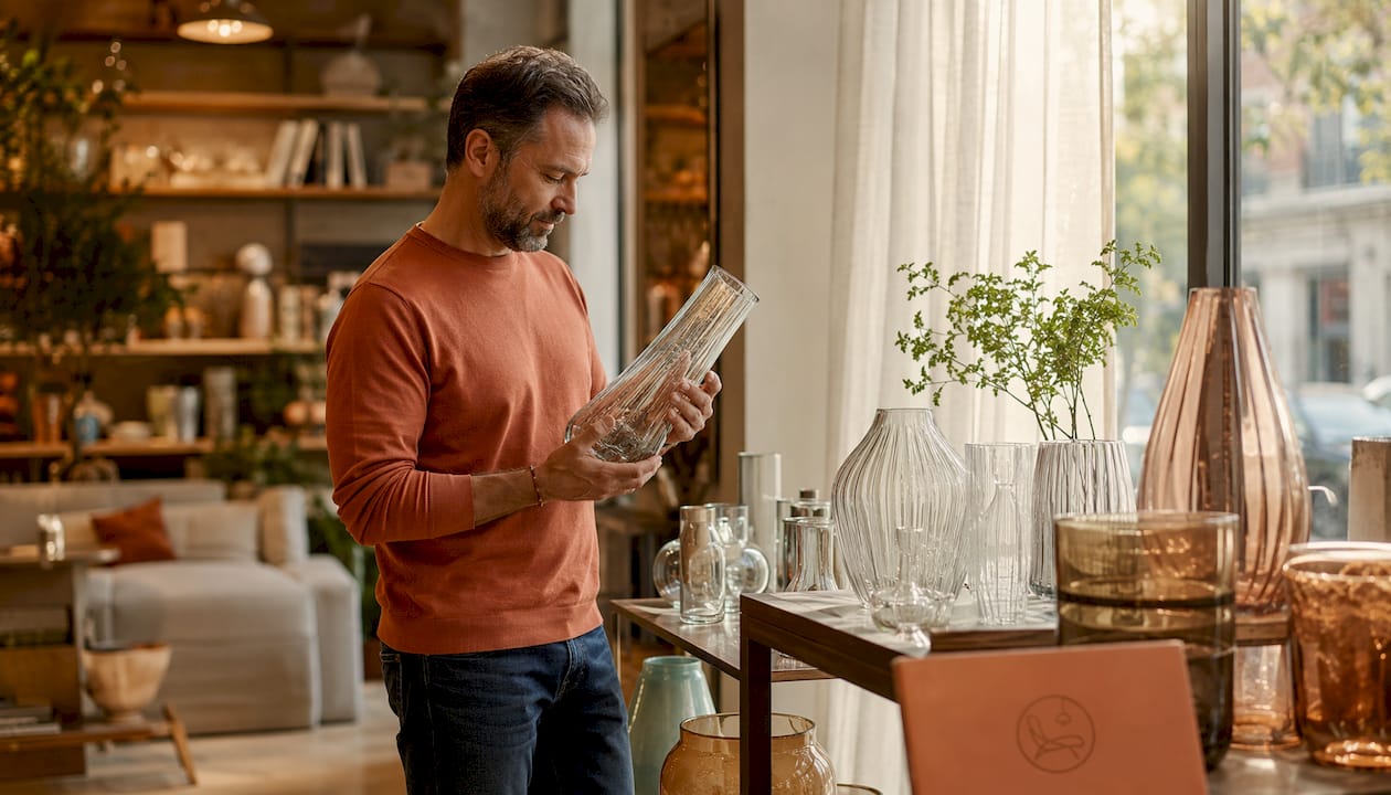 Customer examining glass vase in boutique