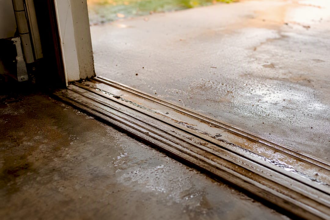 Threshold protecting garage floor edge from moisture