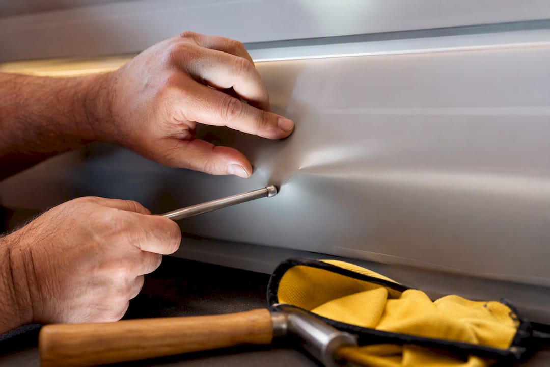 Technician performing paintless dent removal