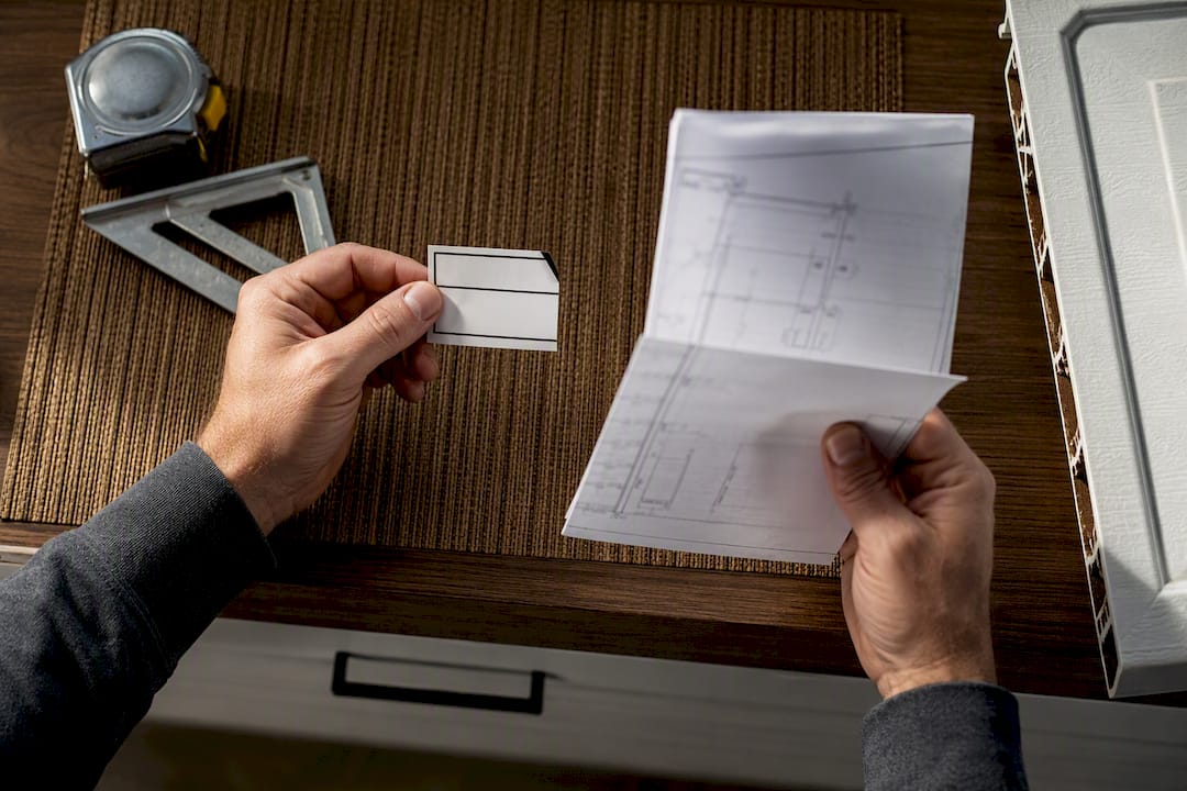Hands comparing garage door documents