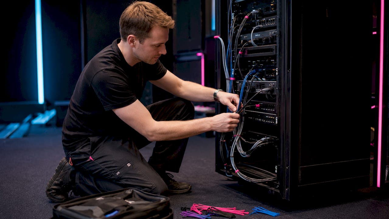Hands connecting cables on AV mixer console
