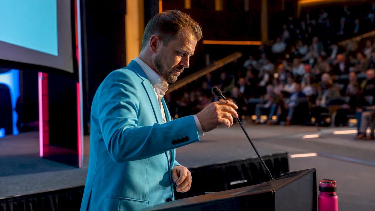 Speaker preparing on moderately raised conference stage platform