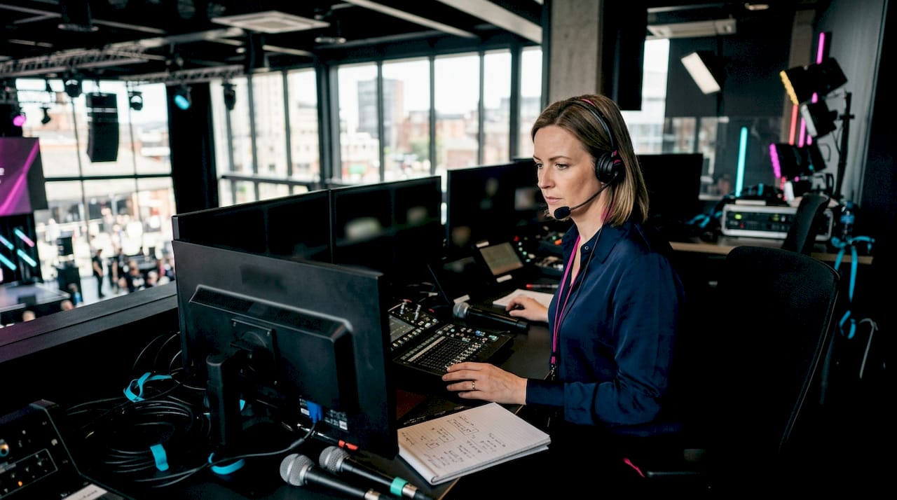 Woman monitoring AV equipment in control room