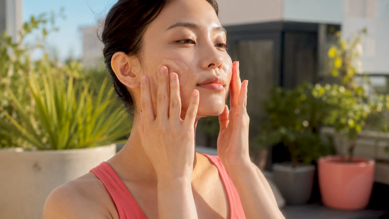 Hands applying watery Japanese sunscreen gel