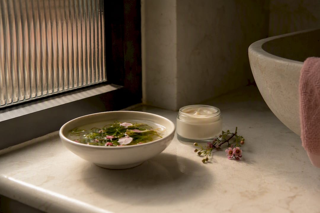 Hazel twigs soaking with cream and leaves on vanity