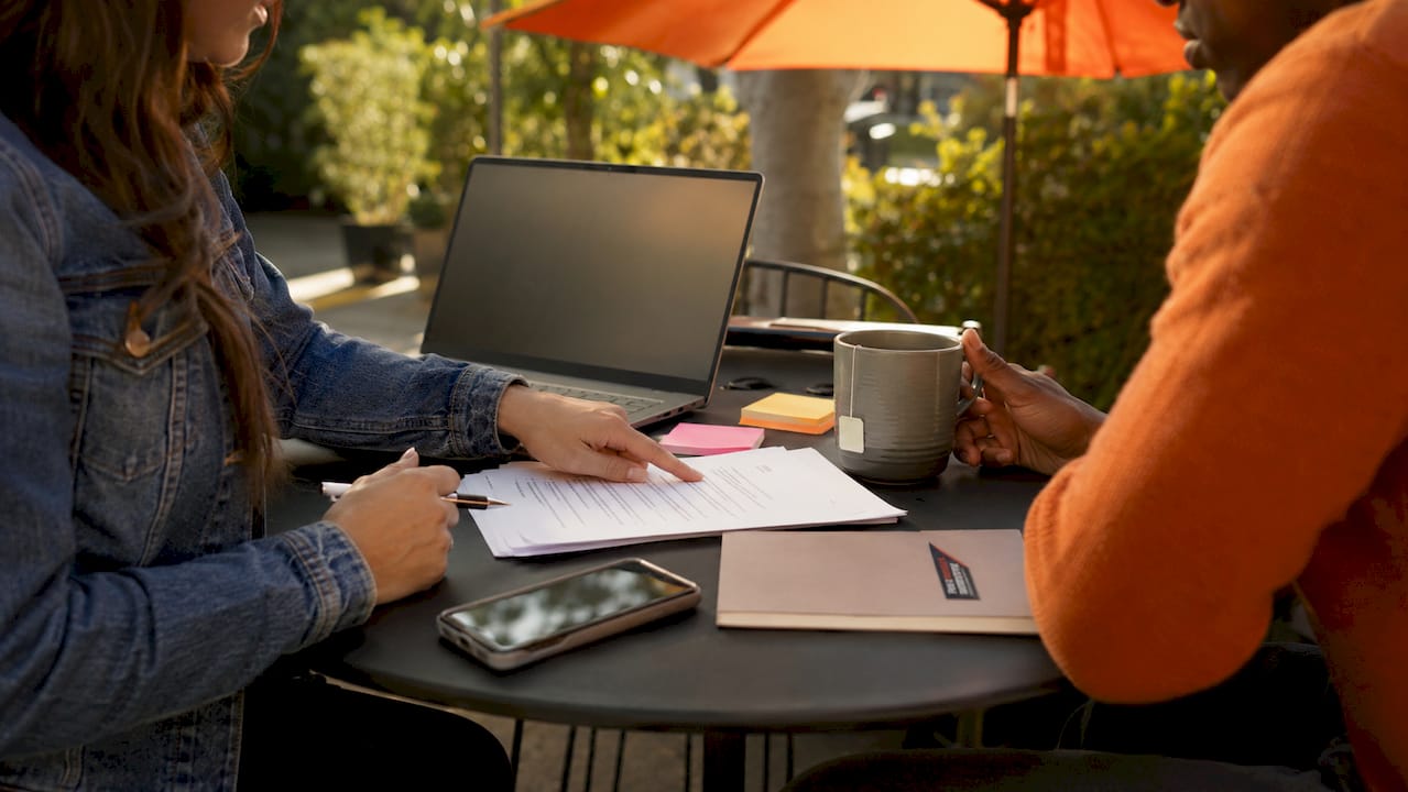 Hands pointing at job description draft on table