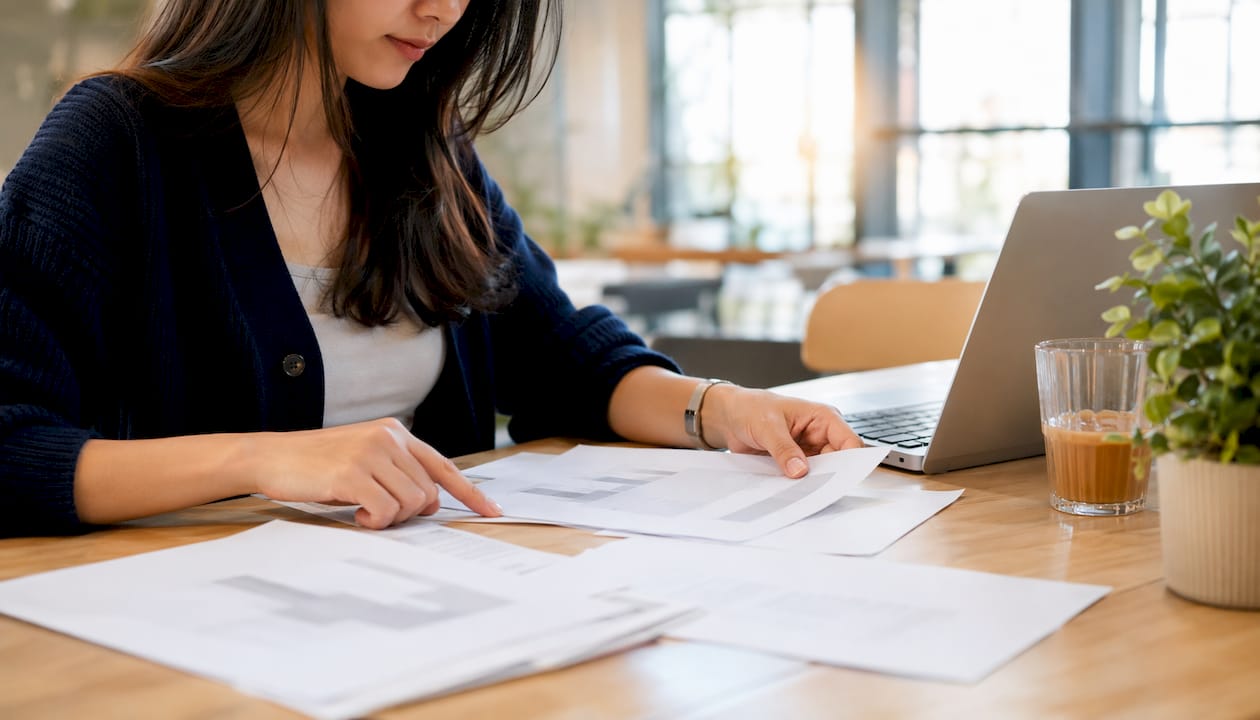 Hands reviewing SaaS contract templates in café