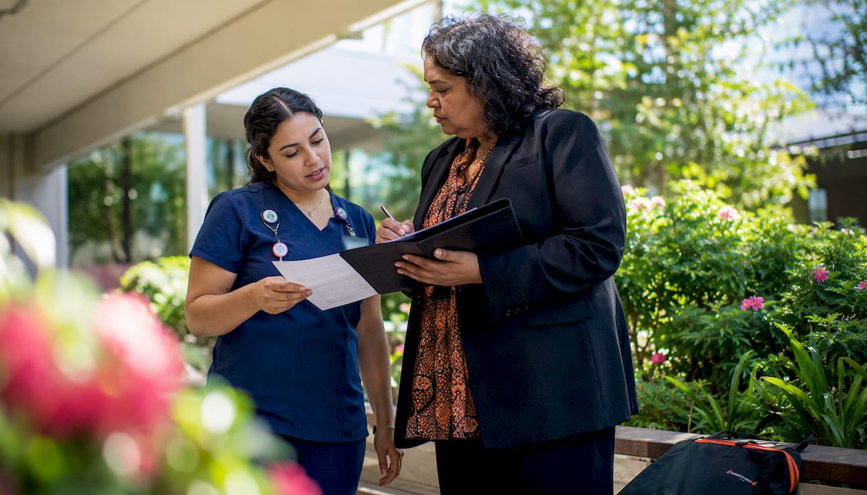 Nurse and manager discussing schedules in hospital