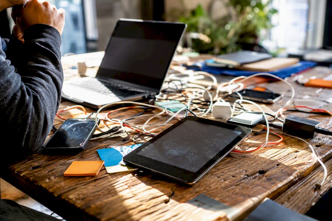 Cluttered desk with devices and cables