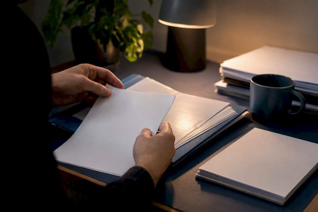 Hands sorting contract template versions on desk