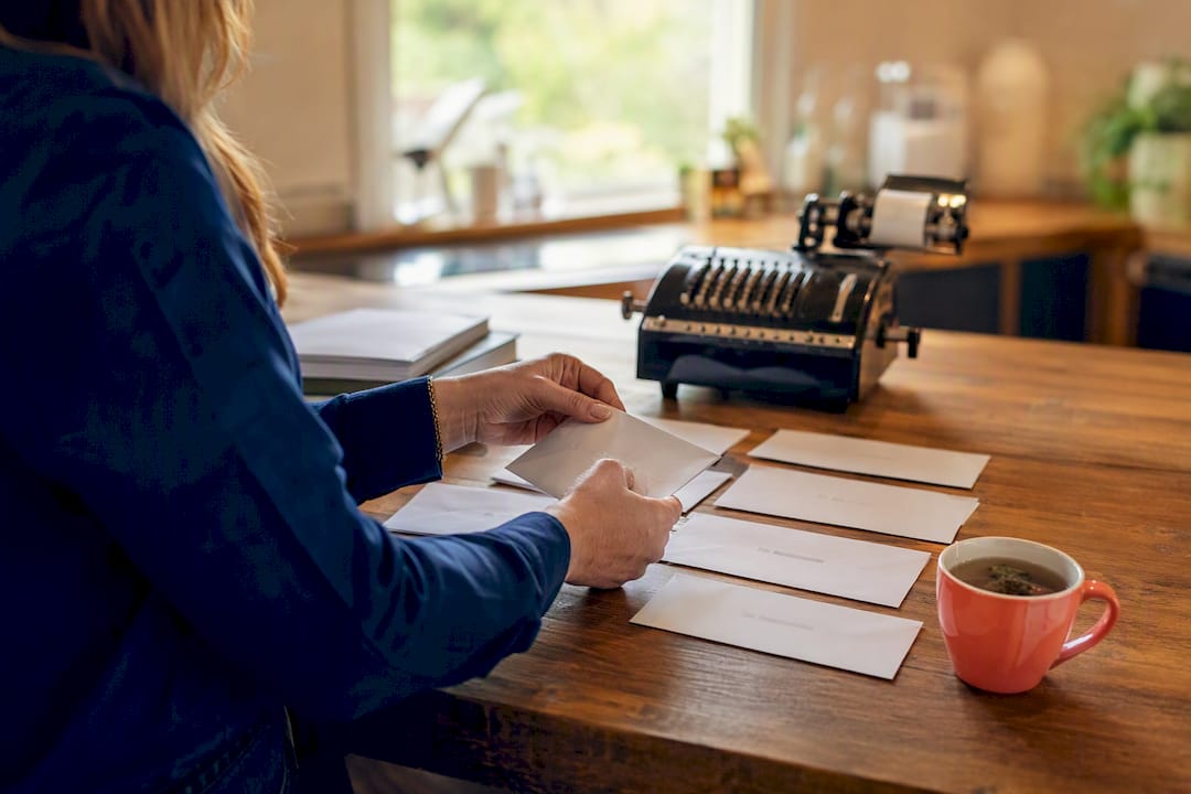 Hands sorting hire cost envelopes on table