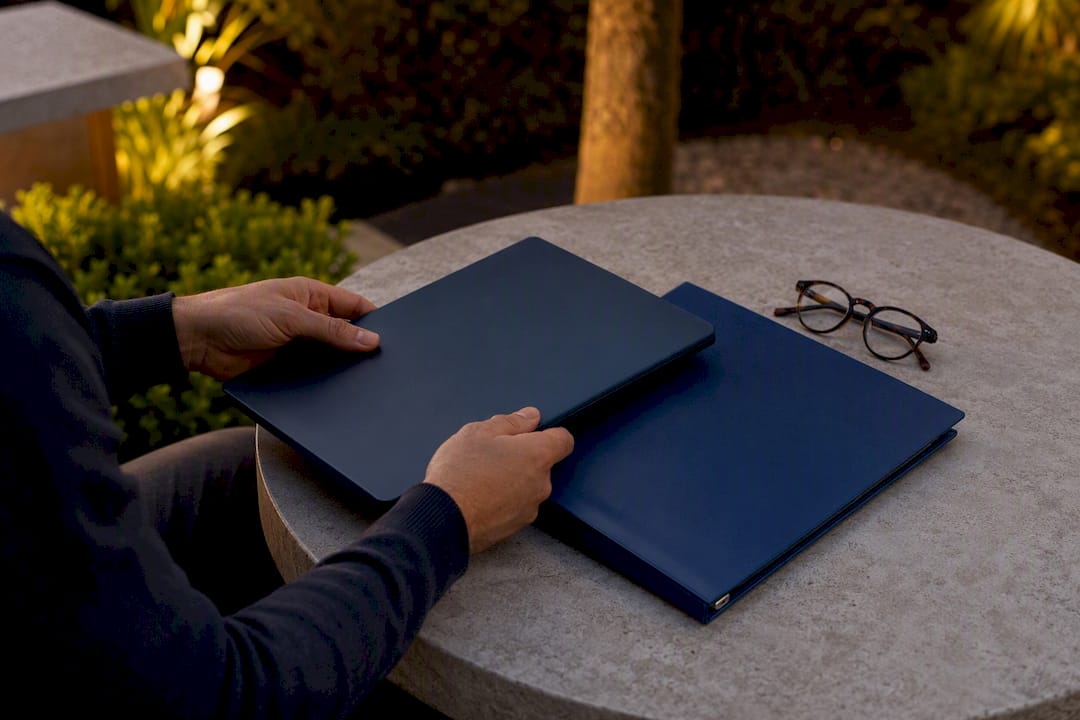 Hands holding closed laptop auditing job descriptions