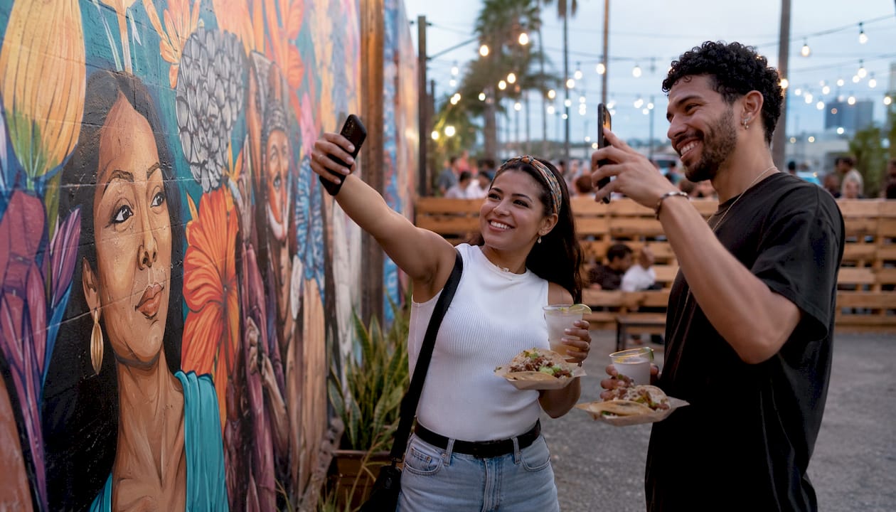 Friends photographing mural in brewery