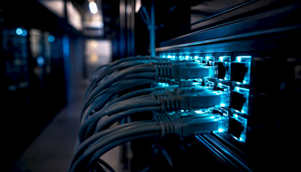 Glowing network cables plugged into server rack