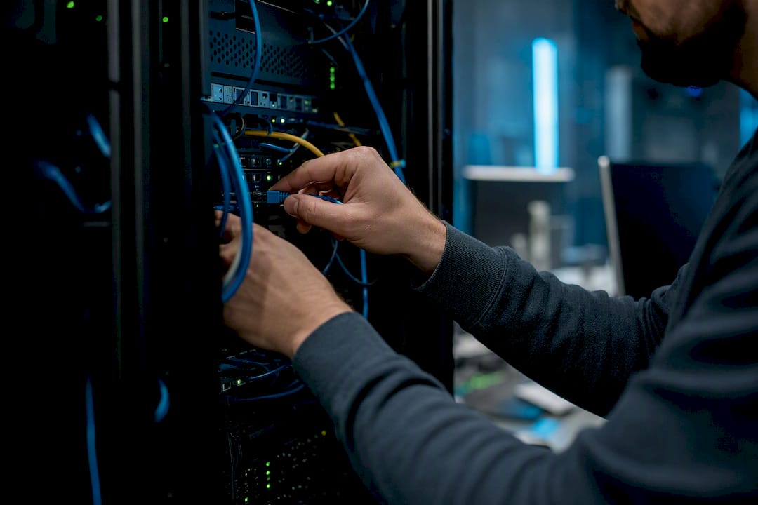 Engineer’s hand unplugging network cable in data center