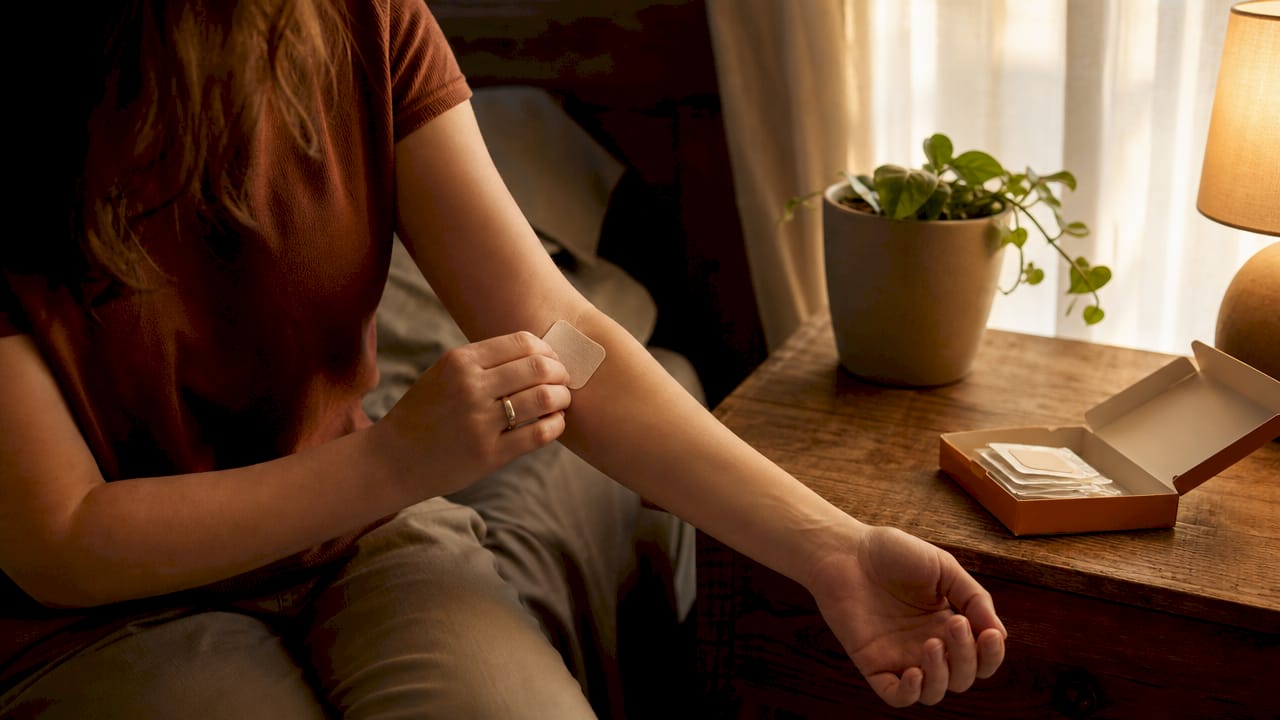 Hands applying nicotine replacement patch