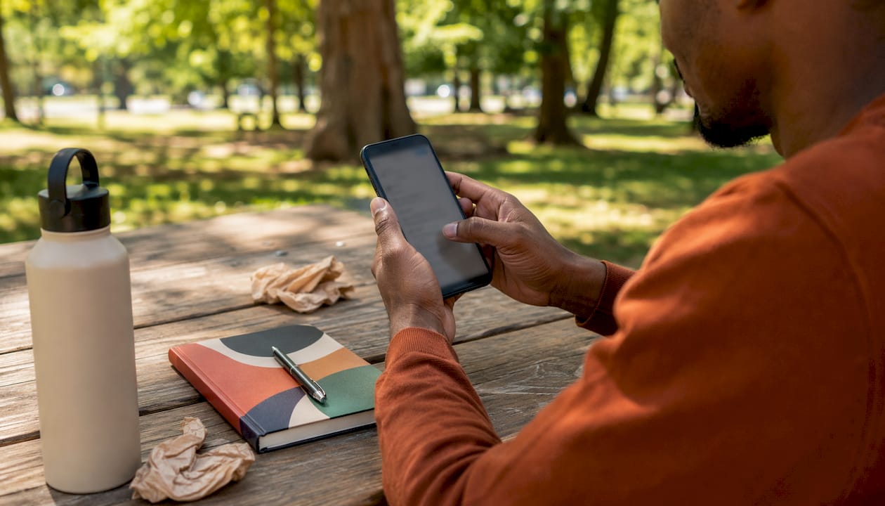 Hands adjusting privacy settings on smartphone in café