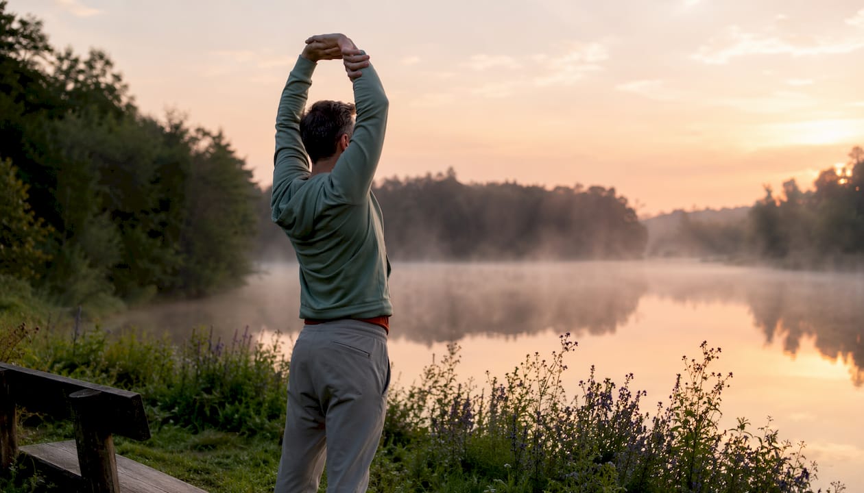 Man stretching outdoors to manage stress