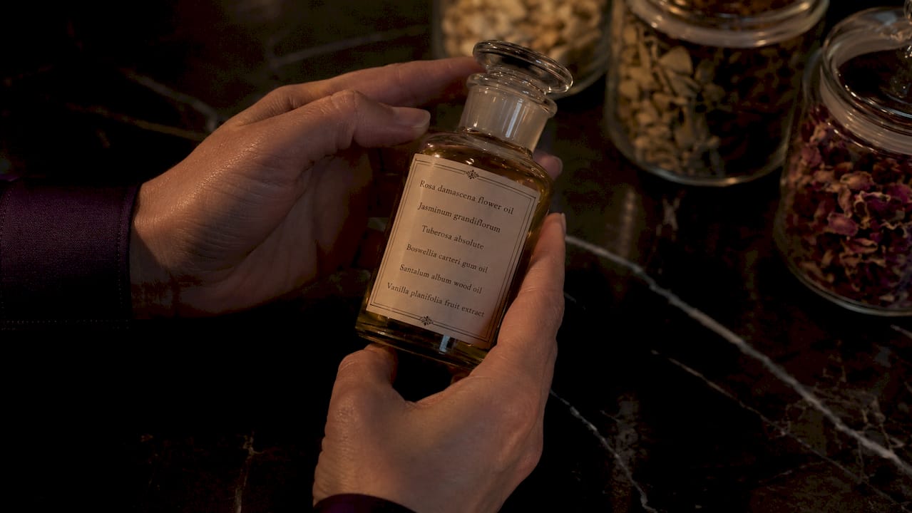 Close-up of hands and natural fragrance ingredient label