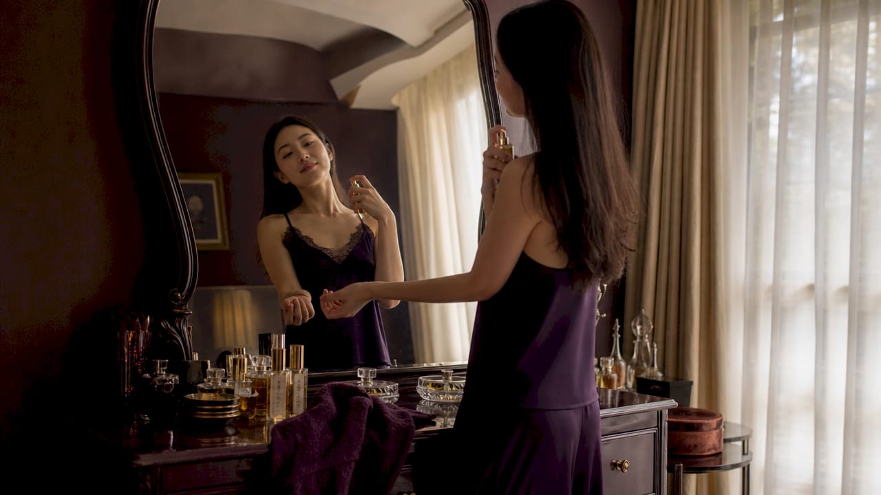 Hands applying layered fragrances on pulse points