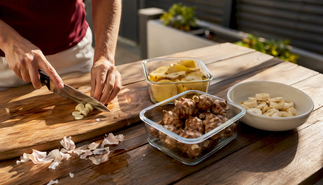 Hands chopping prebiotic foods on kitchen counter