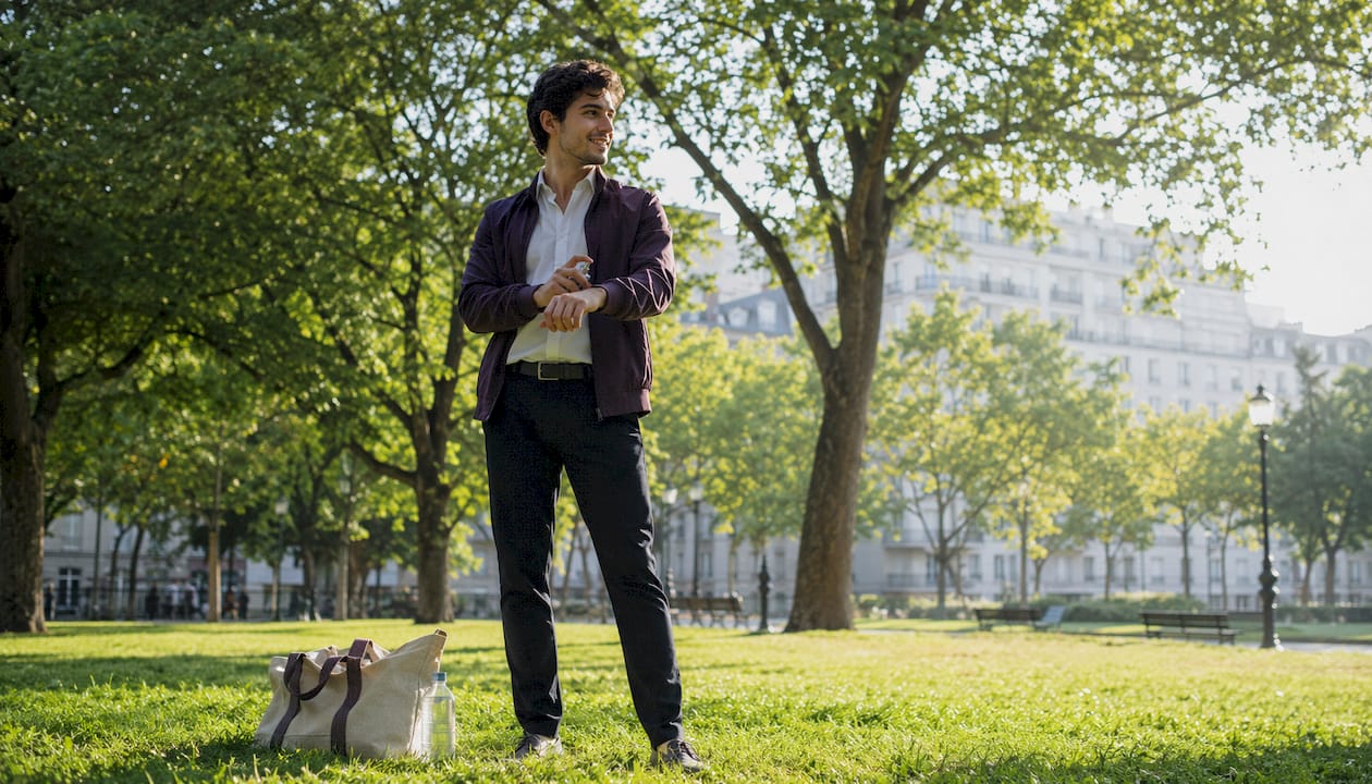 Un homme vaporise un parfum d’agrumes sur sa terrasse.