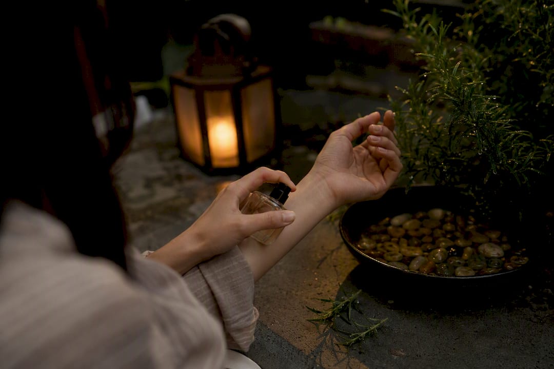 Hands applying perfume in a mindful ritual